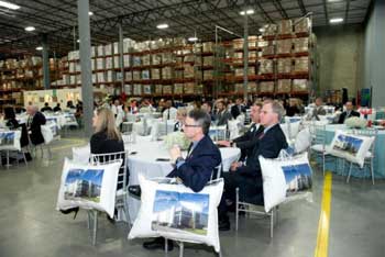 people sitting at tables in a wharehouse 